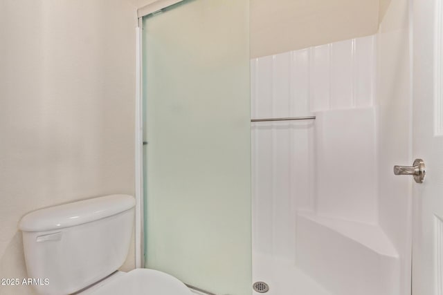 full bathroom featuring toilet and a shower stall