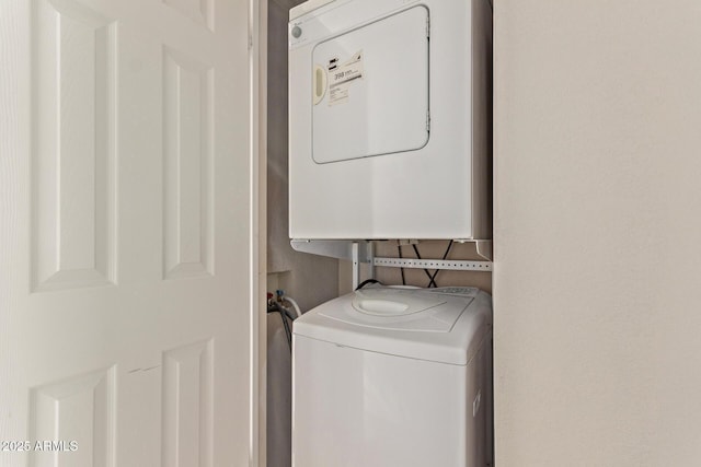 clothes washing area featuring laundry area and stacked washing maching and dryer