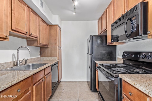 kitchen featuring light tile patterned flooring, brown cabinetry, a sink, and black appliances