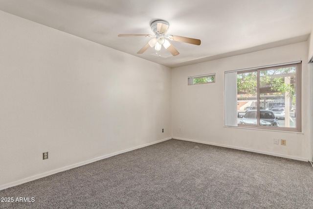 carpeted spare room with ceiling fan and baseboards