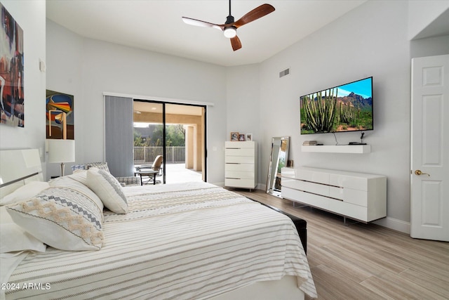 bedroom featuring ceiling fan, light hardwood / wood-style floors, a high ceiling, and access to outside