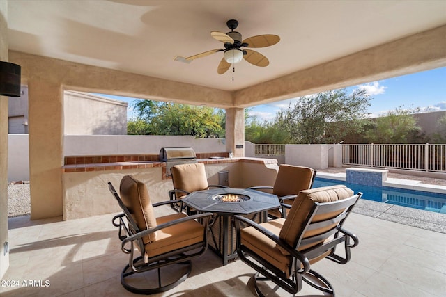 view of patio with a fenced in pool, ceiling fan, and exterior kitchen