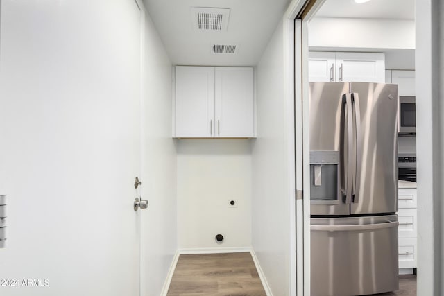 laundry area featuring light hardwood / wood-style flooring and electric dryer hookup