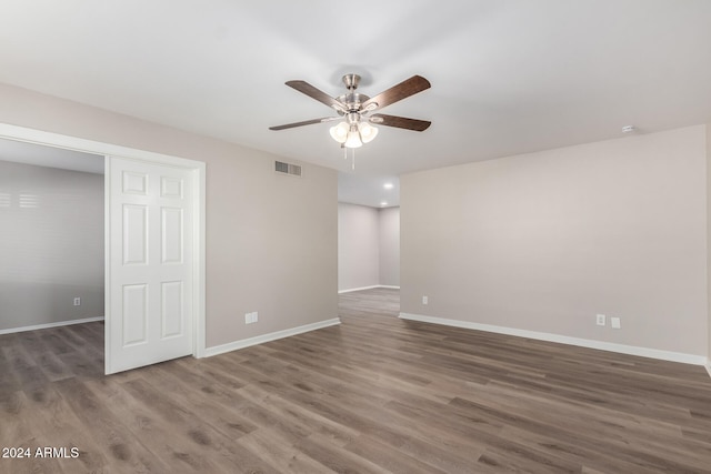 empty room with dark hardwood / wood-style flooring and ceiling fan