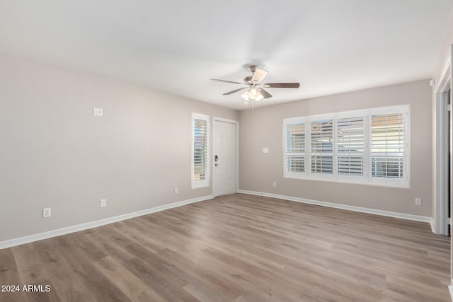 empty room with ceiling fan and light hardwood / wood-style flooring