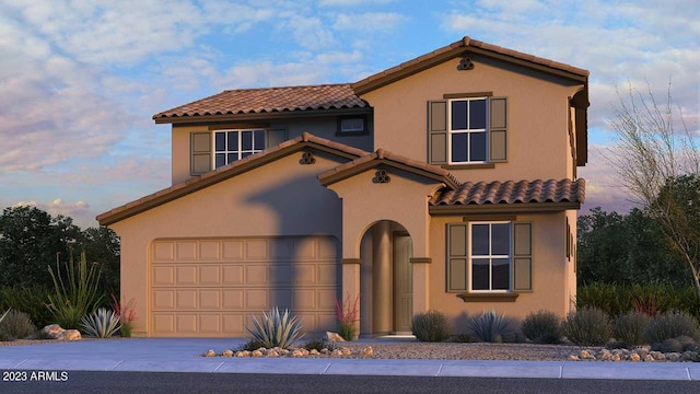 mediterranean / spanish-style home featuring driveway, a tiled roof, and stucco siding