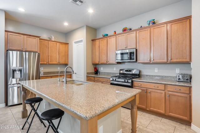 4630 E Navigator Ln, Phoenix, AZ 85050 - kitchen featuring stainless steel appliances, a sink, a breakfast bar area, light tile patterned floors, and light stone counters