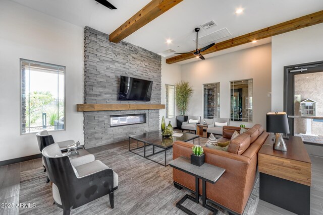 4630 E Navigator Ln, Phoenix, AZ 85050 - living area with beam ceiling, a towering ceiling, a stone fireplace, wood finished floors, and a ceiling fan