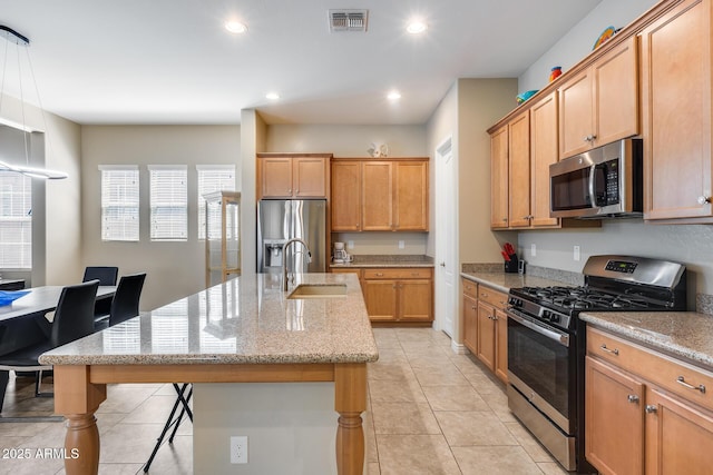4630 E Navigator Ln, Phoenix, AZ 85050 - kitchen featuring appliances with stainless steel finishes, a sink, a kitchen island with sink, light tile patterned floors, and light stone counters