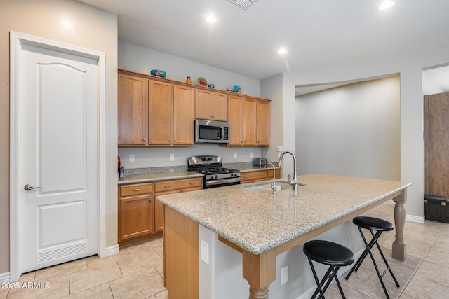 4630 E Navigator Ln, Phoenix, AZ 85050 - kitchen featuring stainless steel appliances, a sink, a breakfast bar area, a kitchen island with sink, and light tile patterned floors