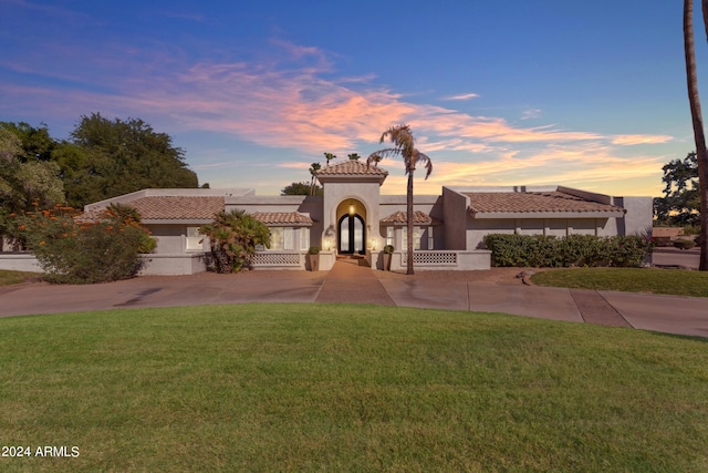 mediterranean / spanish-style house featuring a lawn