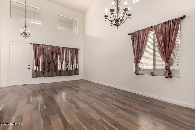 interior space featuring a chandelier, baseboards, and wood finished floors