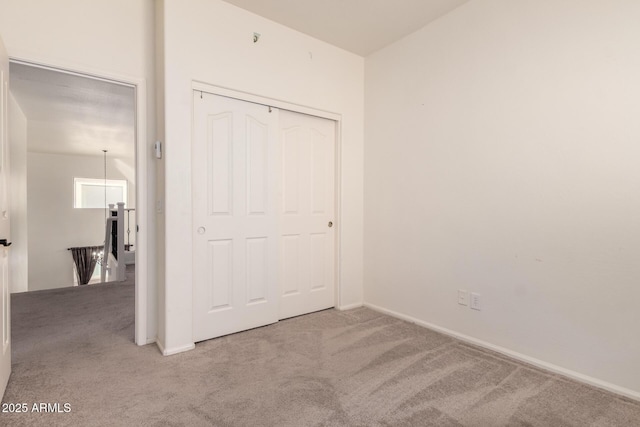 unfurnished bedroom featuring a closet, carpet flooring, and baseboards