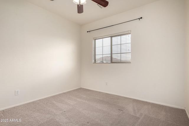 spare room with carpet, baseboards, and a ceiling fan