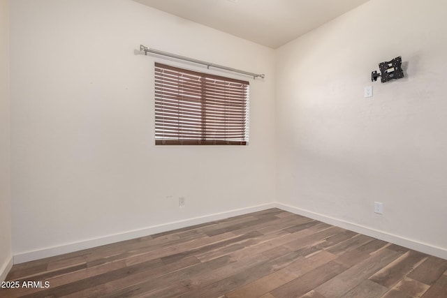 unfurnished room with dark wood-type flooring and baseboards