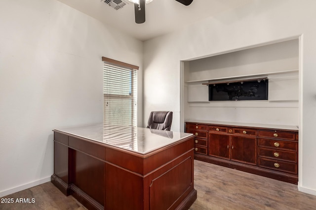 office with baseboards, wood finished floors, visible vents, and a ceiling fan