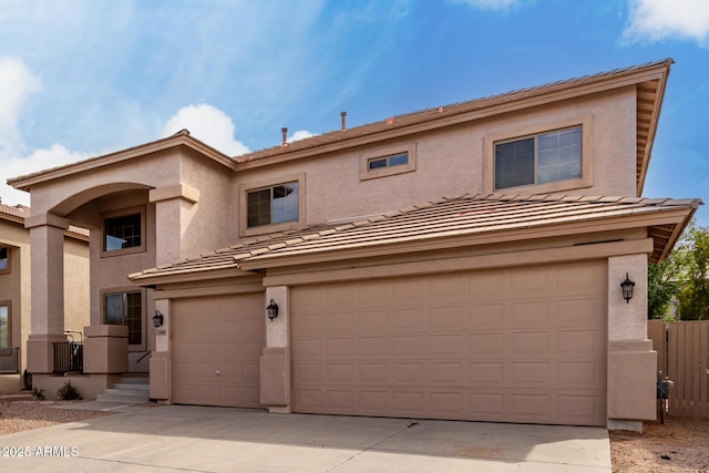 view of front of home featuring a tiled roof, an attached garage, and stucco siding