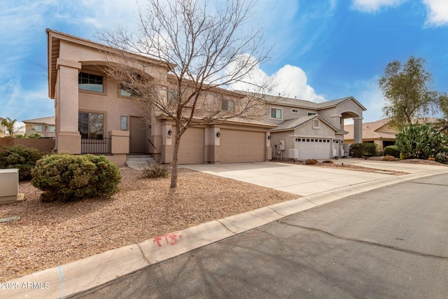 view of front facade with concrete driveway, fence, and stucco siding