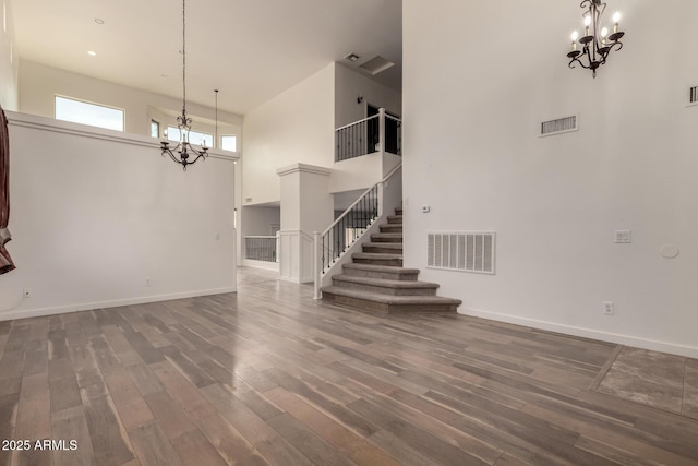 interior space with stairway, visible vents, a chandelier, and wood finished floors