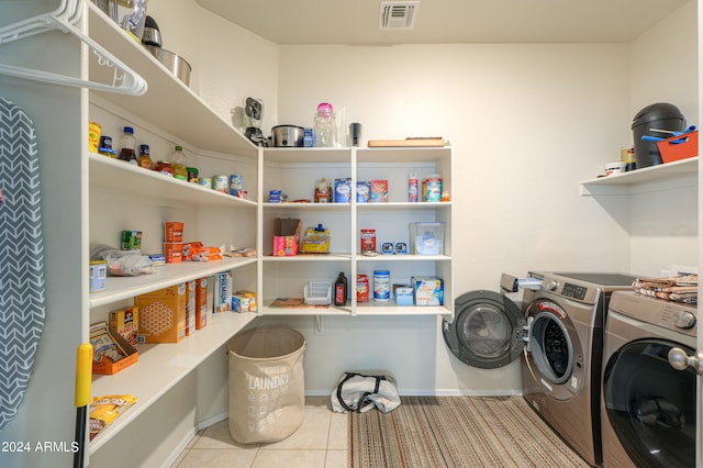 laundry area with light tile patterned flooring and washing machine and dryer