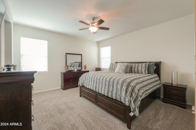 carpeted bedroom featuring ceiling fan and multiple windows