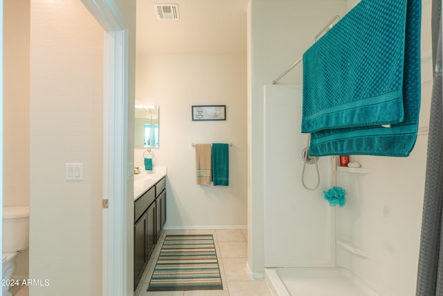 bathroom featuring tile patterned floors, toilet, walk in shower, and vanity