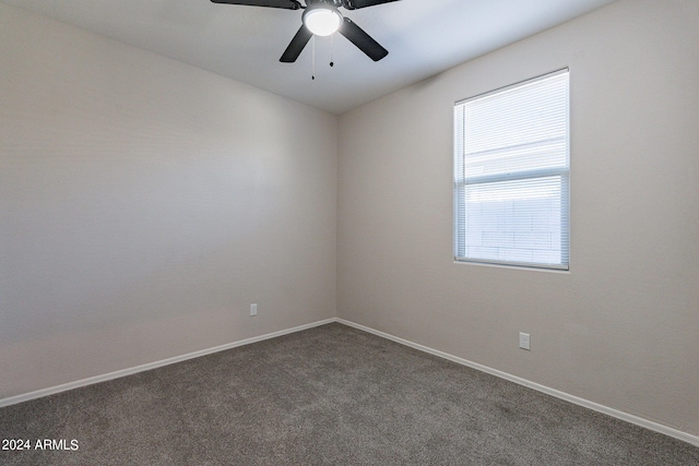 empty room with dark colored carpet and ceiling fan