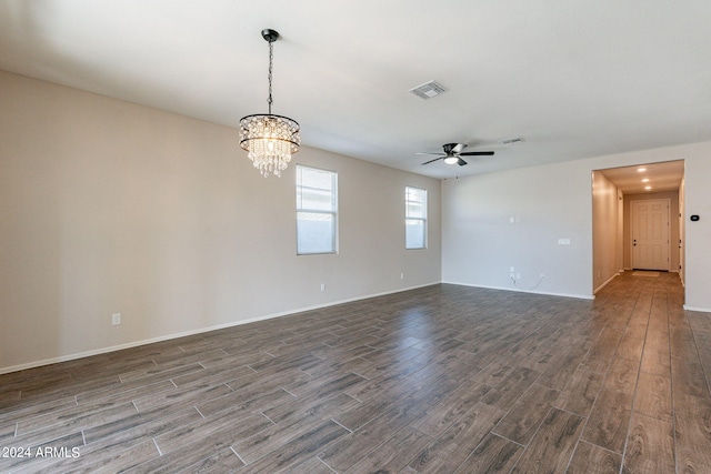 unfurnished room with ceiling fan with notable chandelier and dark hardwood / wood-style floors