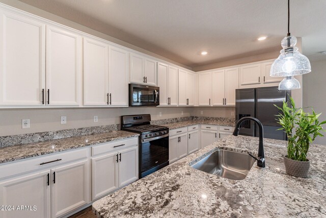 kitchen featuring stainless steel appliances, white cabinetry, hanging light fixtures, and sink