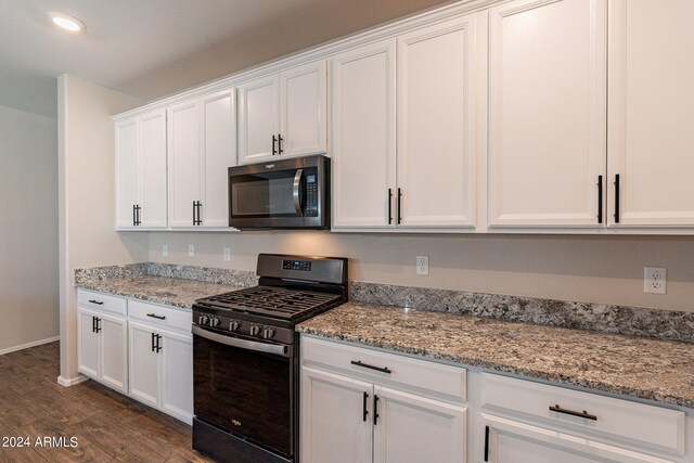 kitchen featuring light stone counters, dark hardwood / wood-style flooring, black range with gas cooktop, and white cabinetry