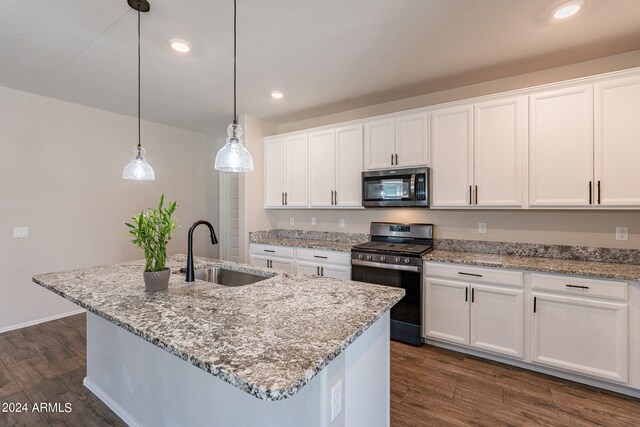 kitchen featuring an island with sink, sink, black gas range oven, and white cabinets