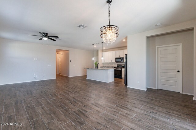 unfurnished living room with ceiling fan with notable chandelier, dark hardwood / wood-style floors, and sink