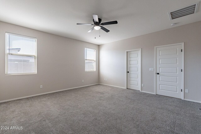 carpeted spare room featuring ceiling fan