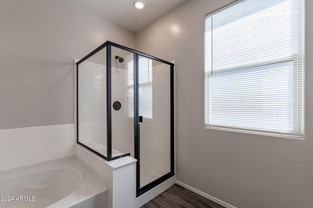 bathroom featuring shower with separate bathtub, hardwood / wood-style flooring, and plenty of natural light