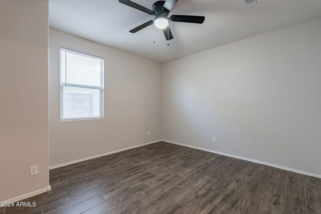 empty room with ceiling fan and dark hardwood / wood-style flooring