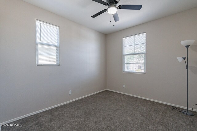 empty room featuring dark colored carpet and ceiling fan