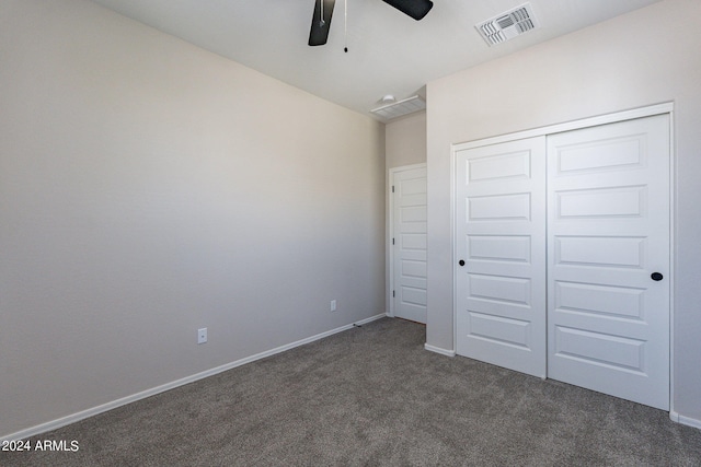 unfurnished bedroom with dark carpet, a closet, and ceiling fan