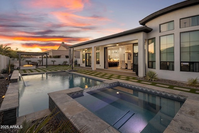 pool at dusk featuring an outdoor fire pit, a patio area, and an in ground hot tub