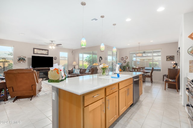 kitchen featuring ceiling fan, sink, stainless steel appliances, and a center island with sink