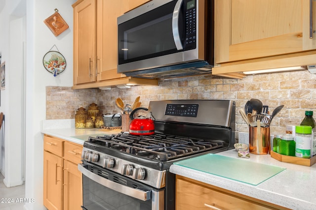 kitchen with backsplash, light brown cabinets, and stainless steel appliances