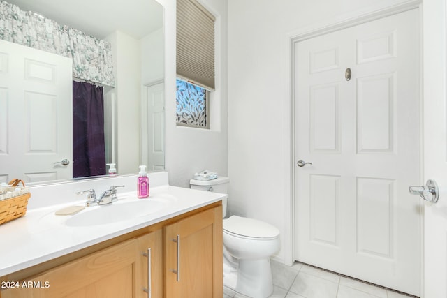 bathroom with tile patterned flooring, vanity, and toilet