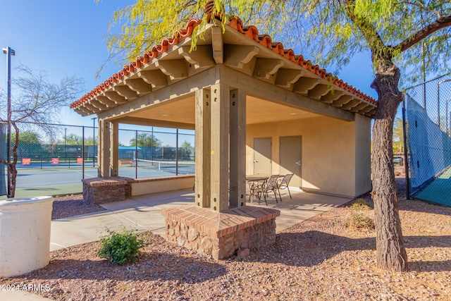 view of patio / terrace with a gazebo and tennis court