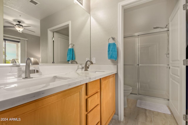 bathroom with double vanity, a stall shower, visible vents, and a sink