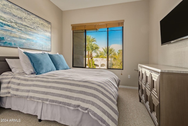 bedroom with baseboards and light colored carpet