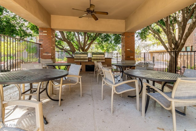 view of patio / terrace featuring an outdoor kitchen, area for grilling, fence, a ceiling fan, and outdoor dining space