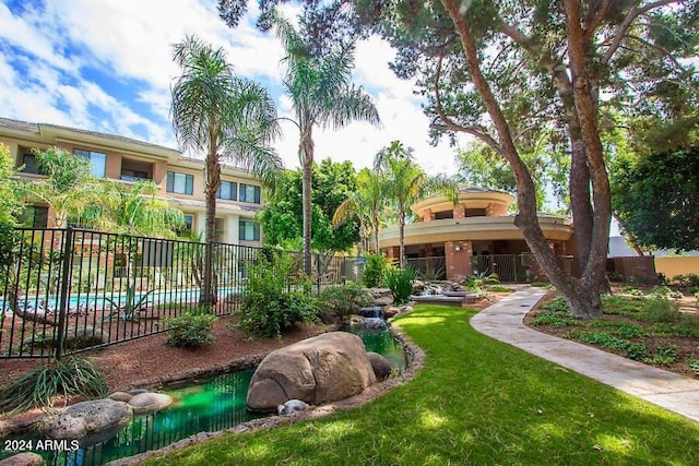 view of home's community with a lawn and fence