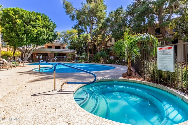 view of swimming pool featuring a hot tub