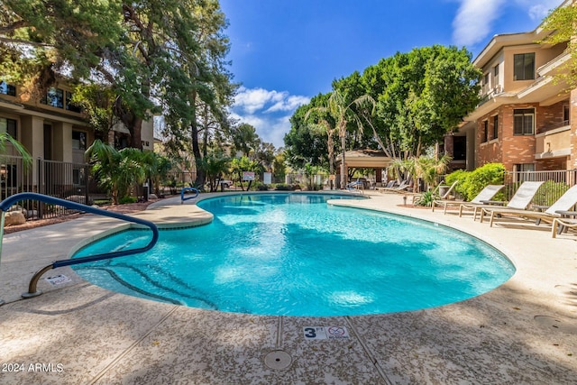 pool with a patio area, fence, and a gazebo