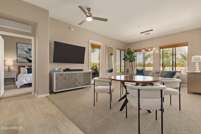 dining room featuring baseboards, visible vents, and ceiling fan with notable chandelier