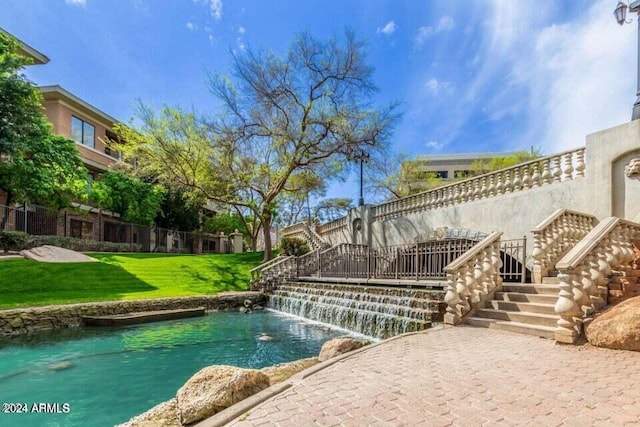 view of swimming pool with stairway, a pool, and a yard